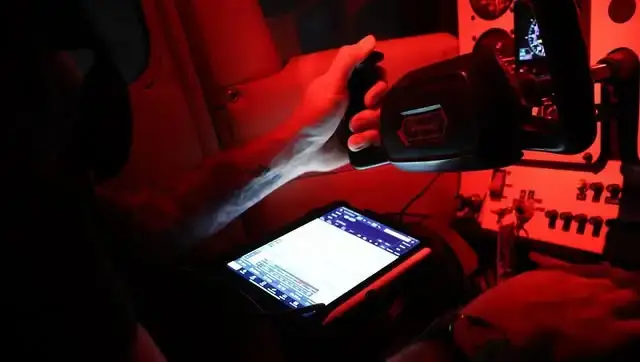 Pilot controlling the yoke under cockpit lighting at night